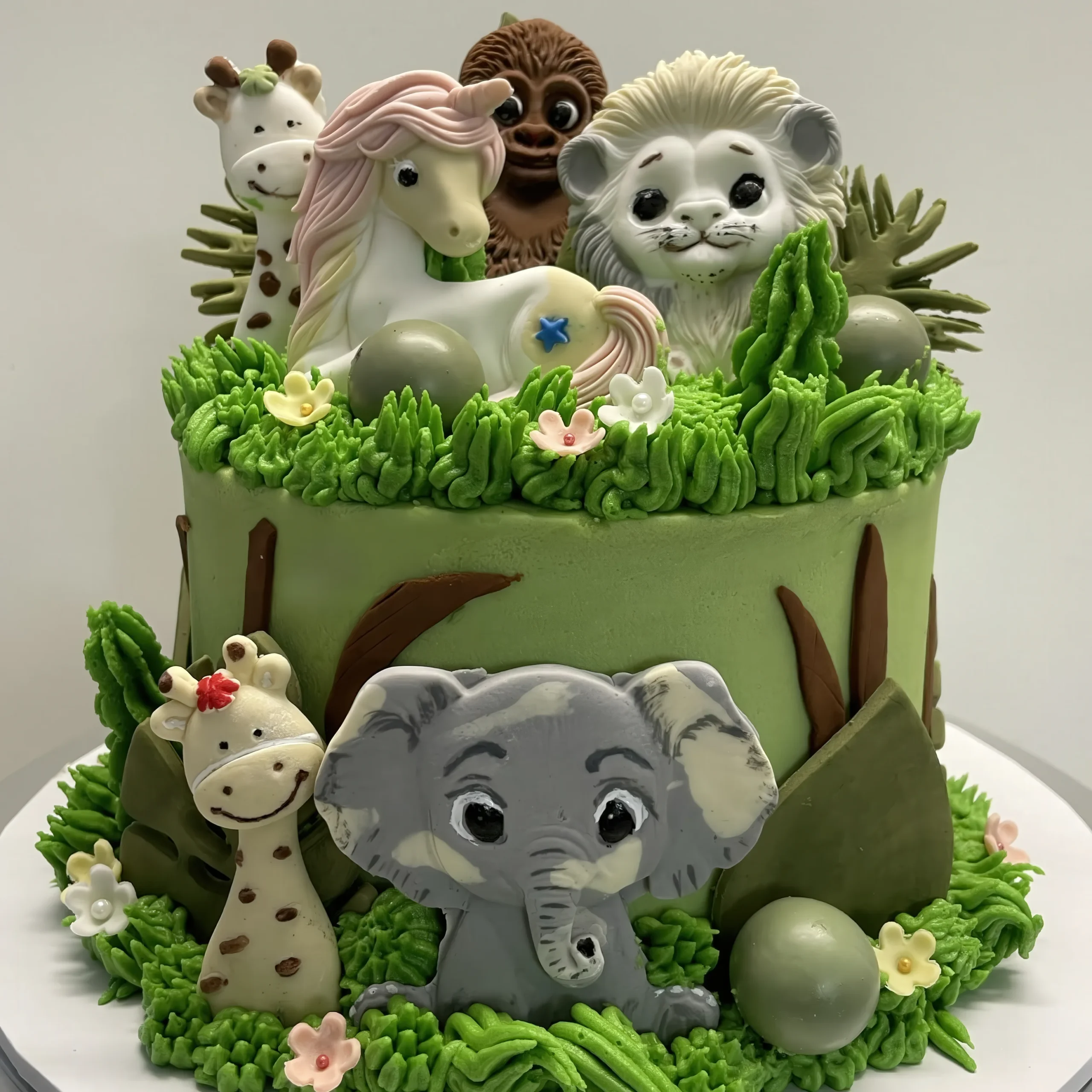 Handmade butter cake decorated with a vibrant jungle theme in vivid colours, featuring playful safari details perfect for a kid’s birthday celebration. Soft, delicious cake with a fun wild adventure design that makes any party extra special!